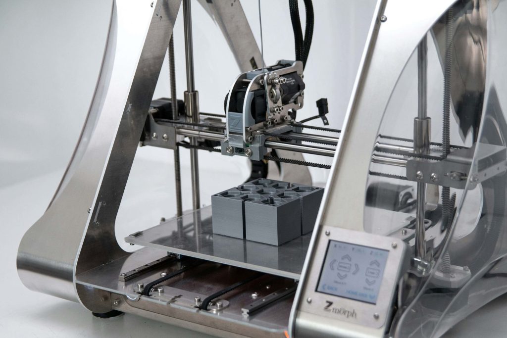 A silver 3D printer resting on a surface