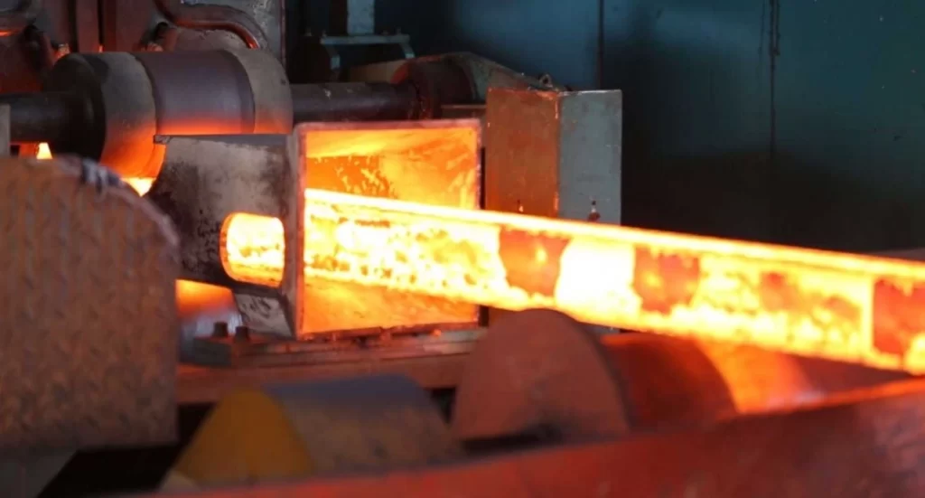 An image of a red-hot rectangular bar of 4140 steel undergoing heat treatment