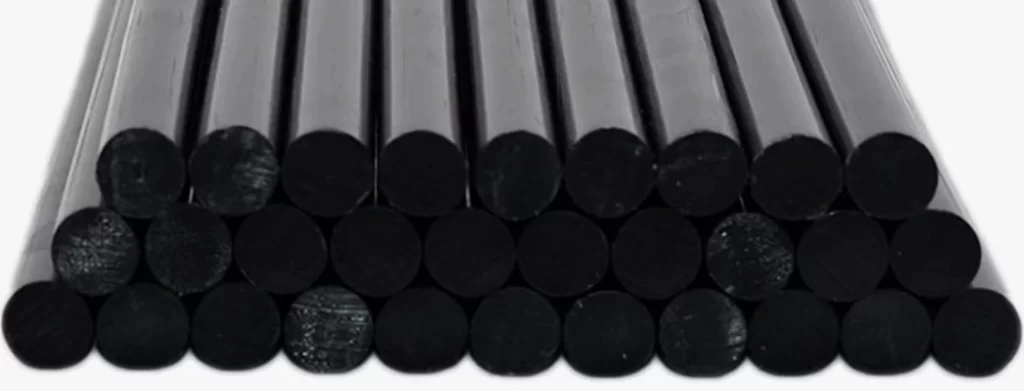 A close-up of a stack of black round bars of 4140 steel