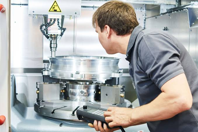 A worker operating a CNC milling machine
