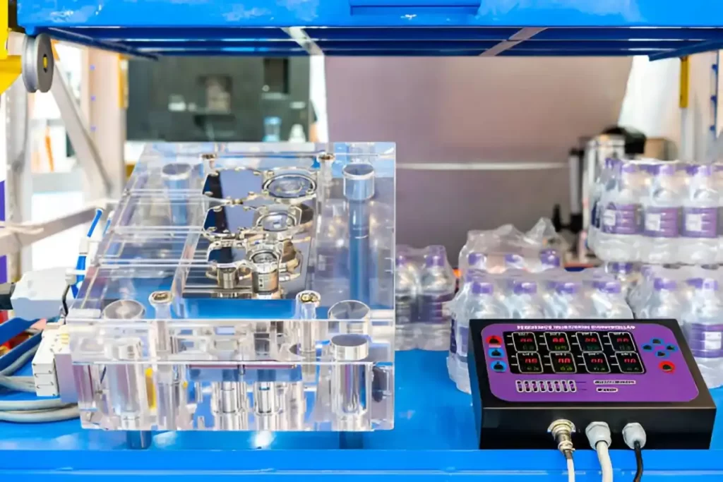 An acrylic plastic mold is shown next to a sequence injection controller box.