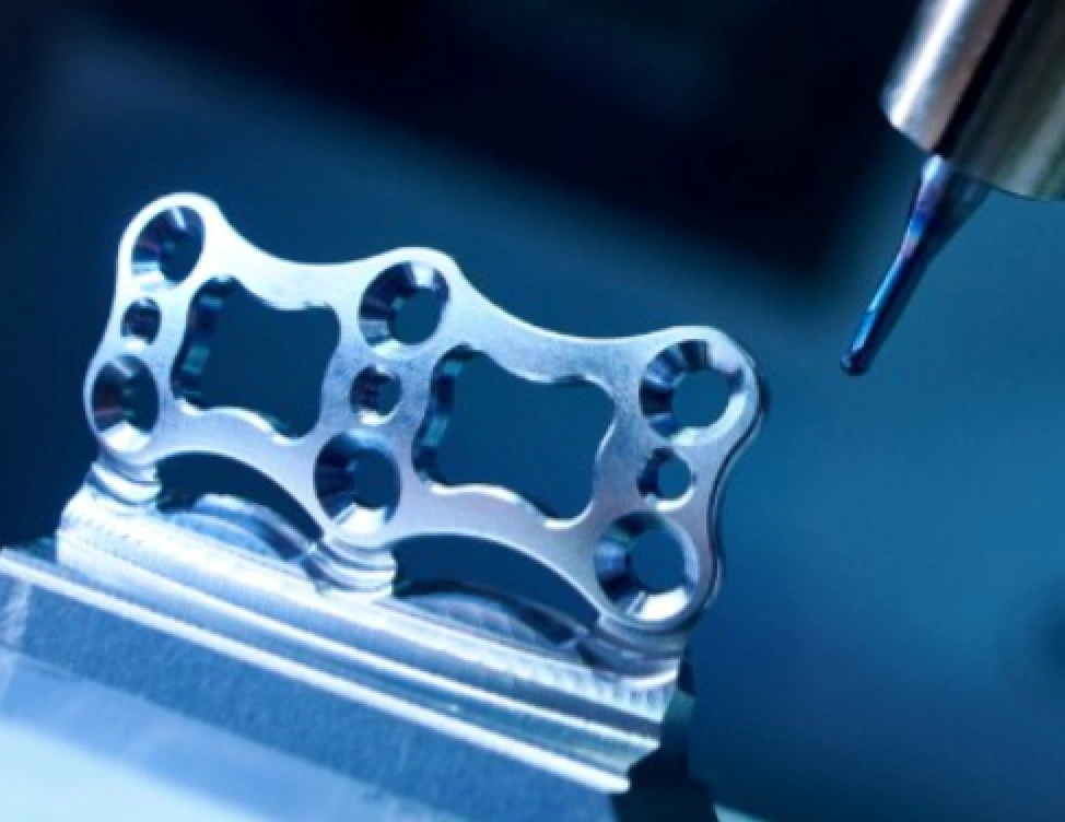 An image of a milling tool alongside a metal plate with a defined profile and holes of different sizes