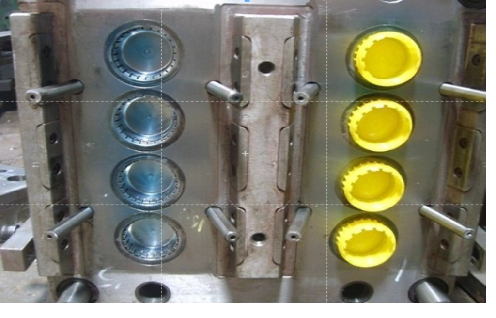 A close-up view of two mold halves showing cavity and yellow-colored bottle caps