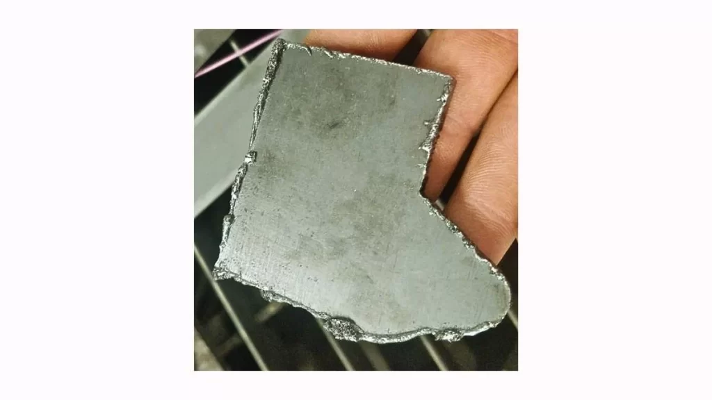 An image showcases the burr formation on the edge of a laser-cut metal part, indicating an issue with the cutting process.