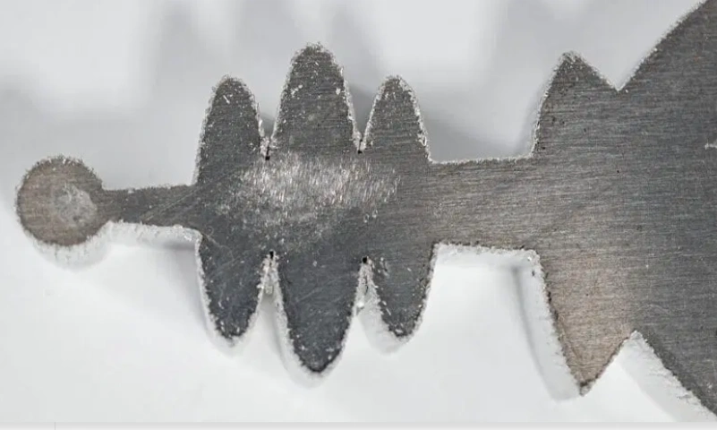 A metal part with burred CNC laser-cut edges
