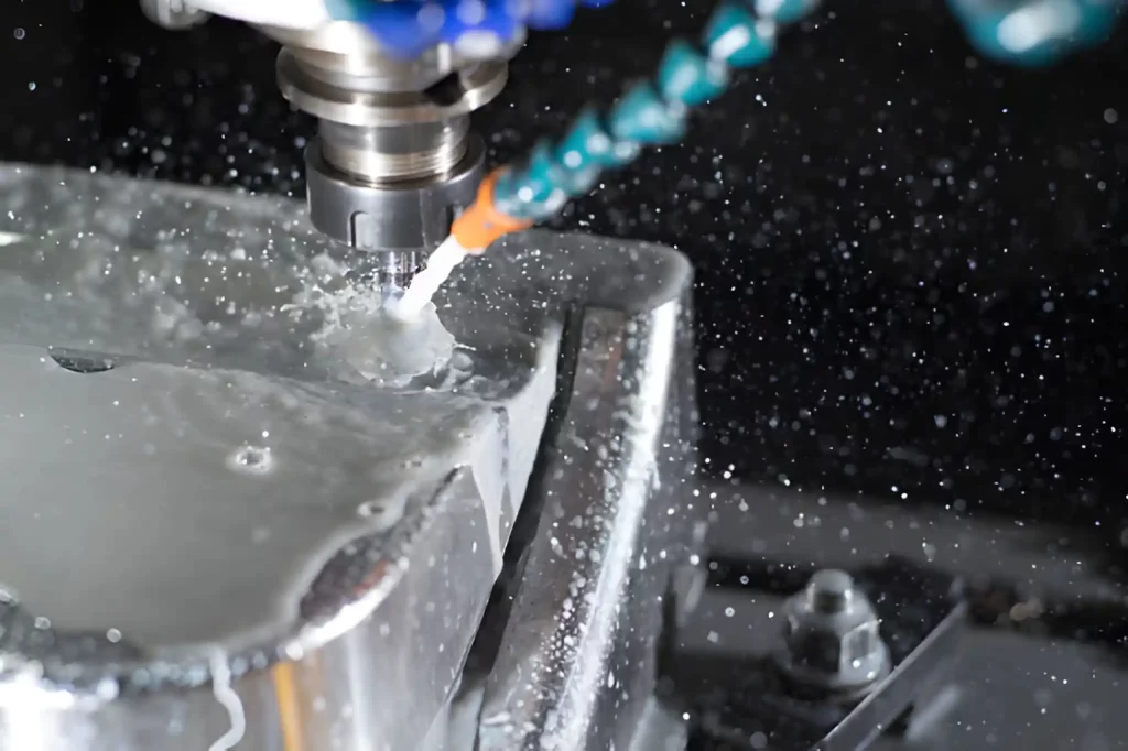 A CNC drilling machine in action with coolant flowing over the drill bit and the metal part.