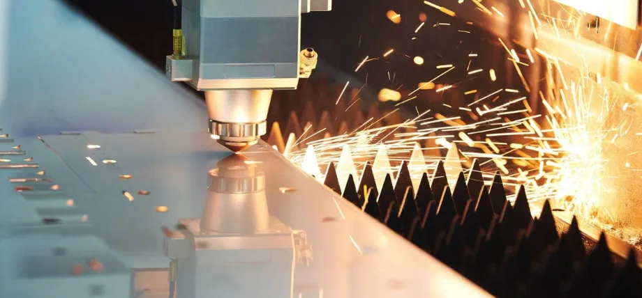 CNC machine making holes in a metal sheet with sparks in background