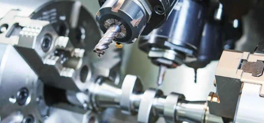 Multiple CNC spindles and end mill cutter with a crank shaft in a jig in the background