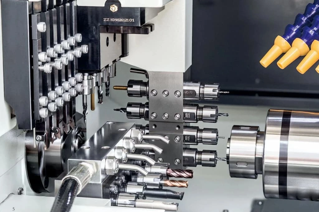 A close-up view of Swiss-type lathe machining, various tools are attached to the ATC mechanism