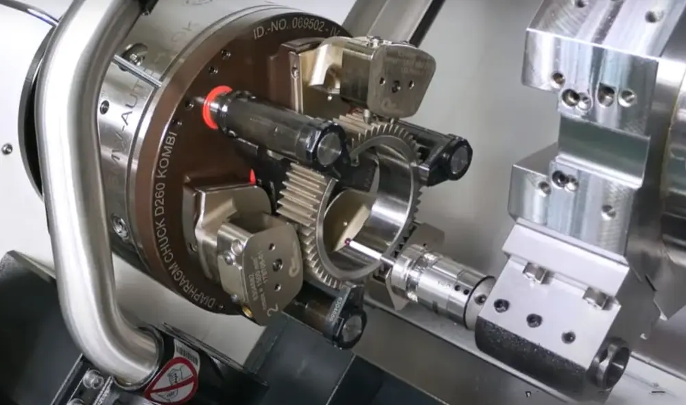 CNC turning center spindle with chuck holding gear component for machining