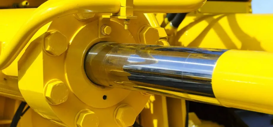 shining chrome cylinder in a yellow machine