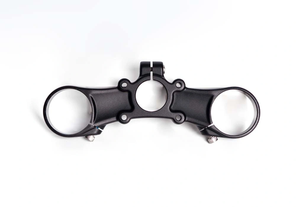 Complex forged aluminum motorcycle triple clamp showing intricate geometry