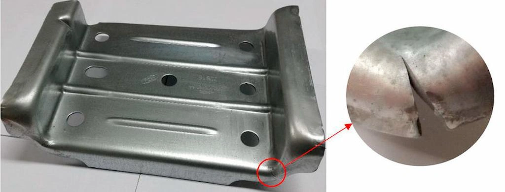 A sheet metal stamped part with a crack on the formed edge and a magnifying view of the crack