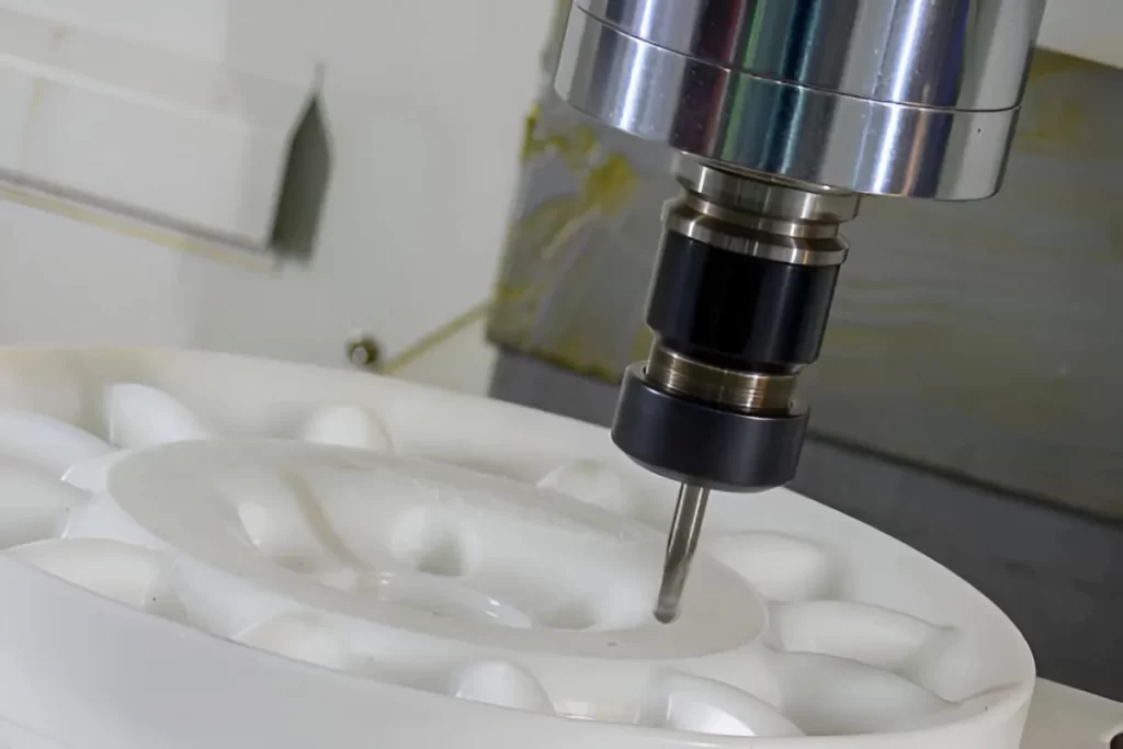 The image shows a Delrin workpiece being shaped on a CNC machine.