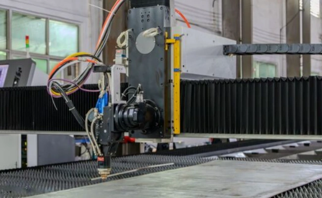 An image of a setup of a metal sheet ready for CNC engraving under a modern-looking CNC laser machine by Epilog