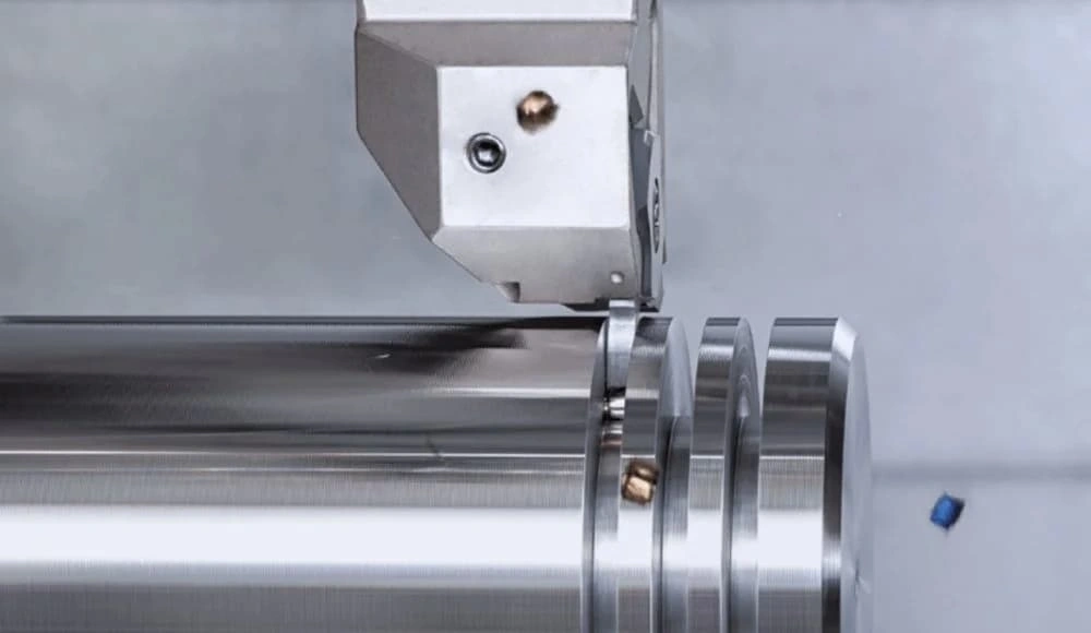 An image showing a cutting tool creating deep grooves on the exterior of a cylindrical shaft.