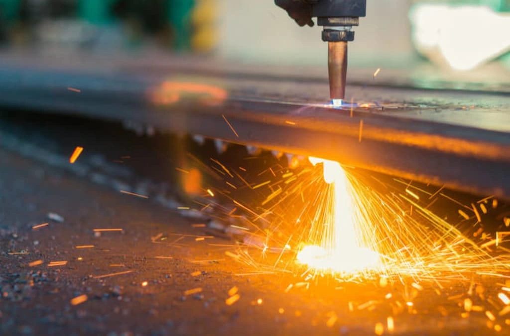 A plasma beam cutting through a thick carbon steel plate