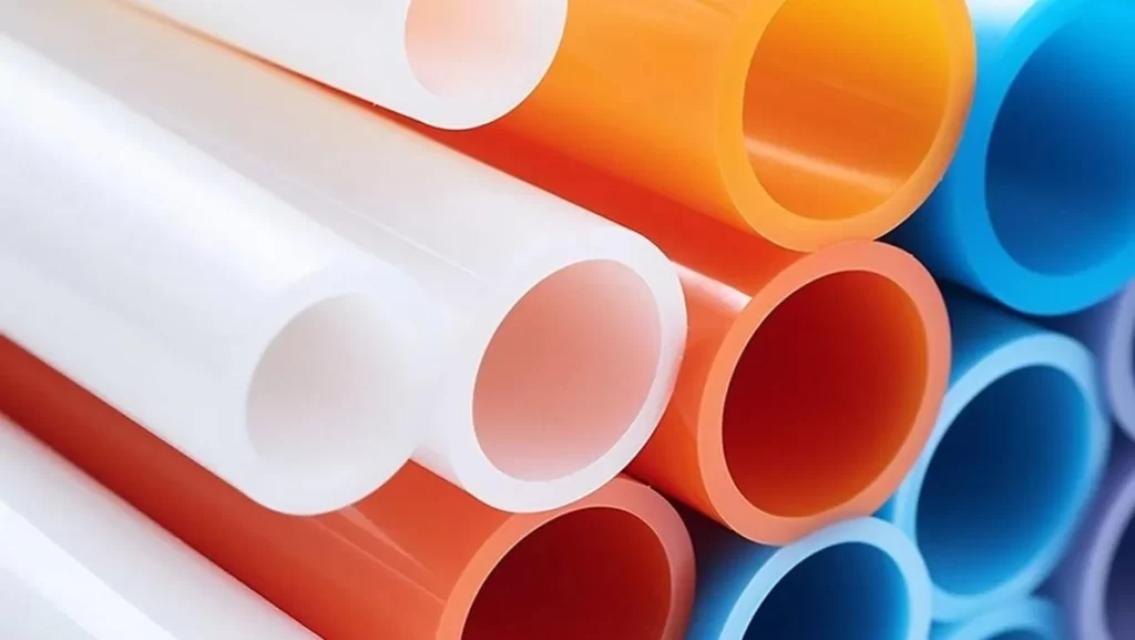 Stack of various colored plastic pipes (white, orange, blue, purple).