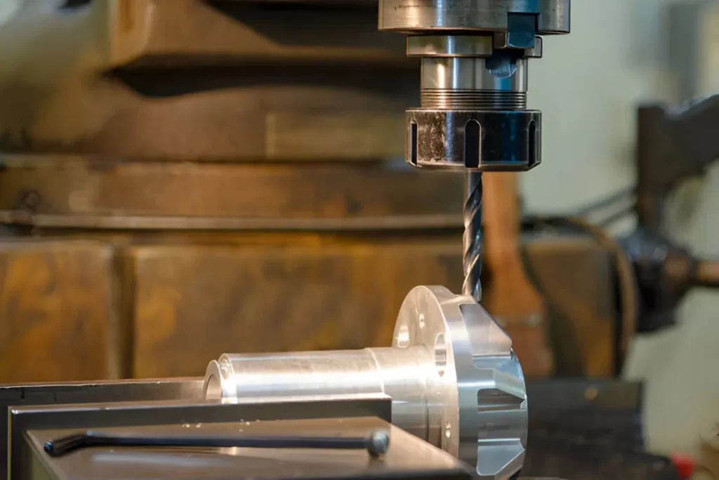 Hole drilling operation on an aluminum part using a CNC machine.