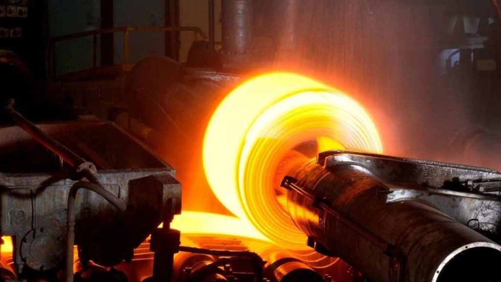 Glowing hot metal coil being processed industrially.