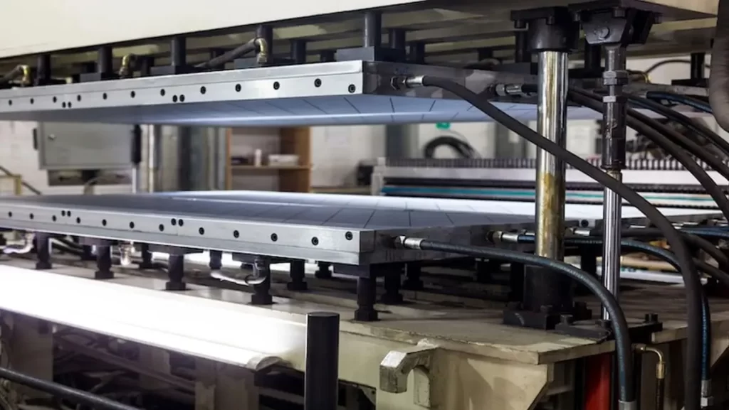 A polycarbonate machine with multiple rollers and a complex metal structure.