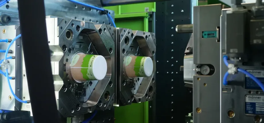 Injection mold with a white and green round plastic object