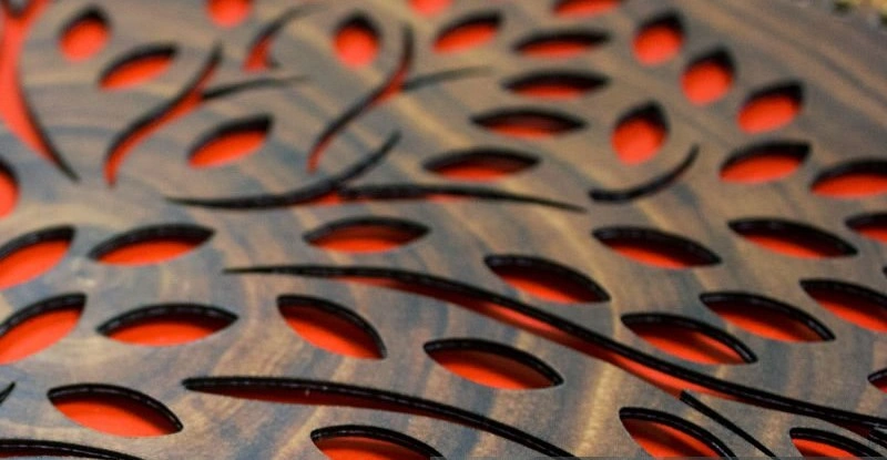 An image of CNC cuts showing intricate flowery and curved features on a grey workpiece
