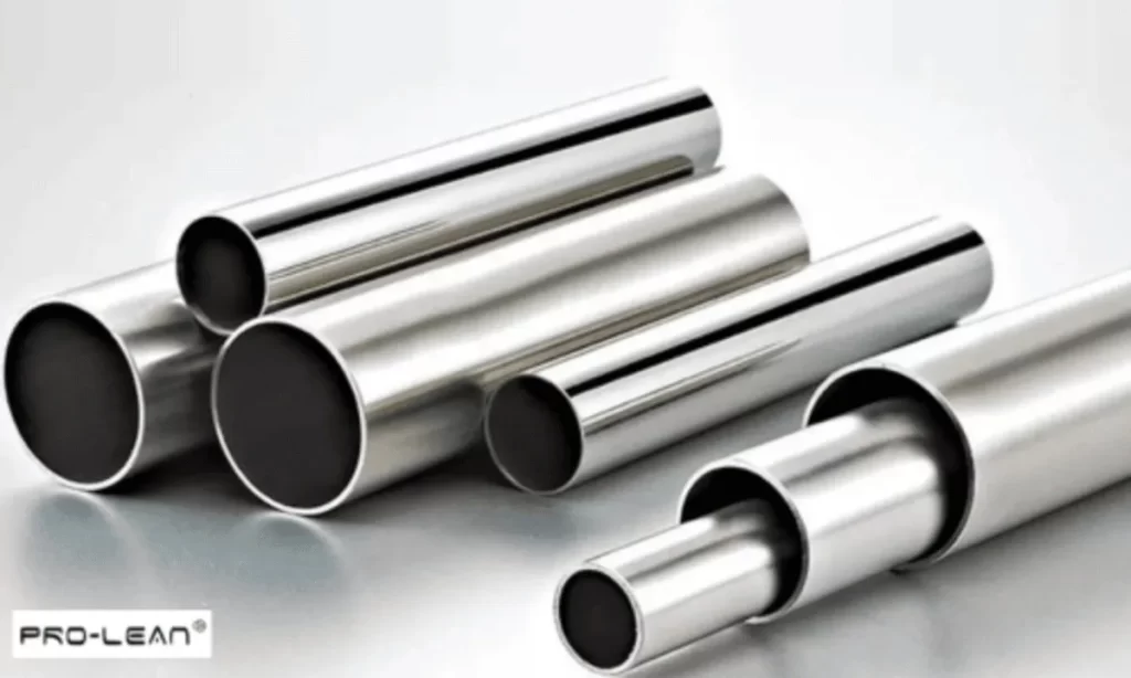 Shiny metal pipes of varying diameters arranged on a light surface, showcasing industrial materials.
