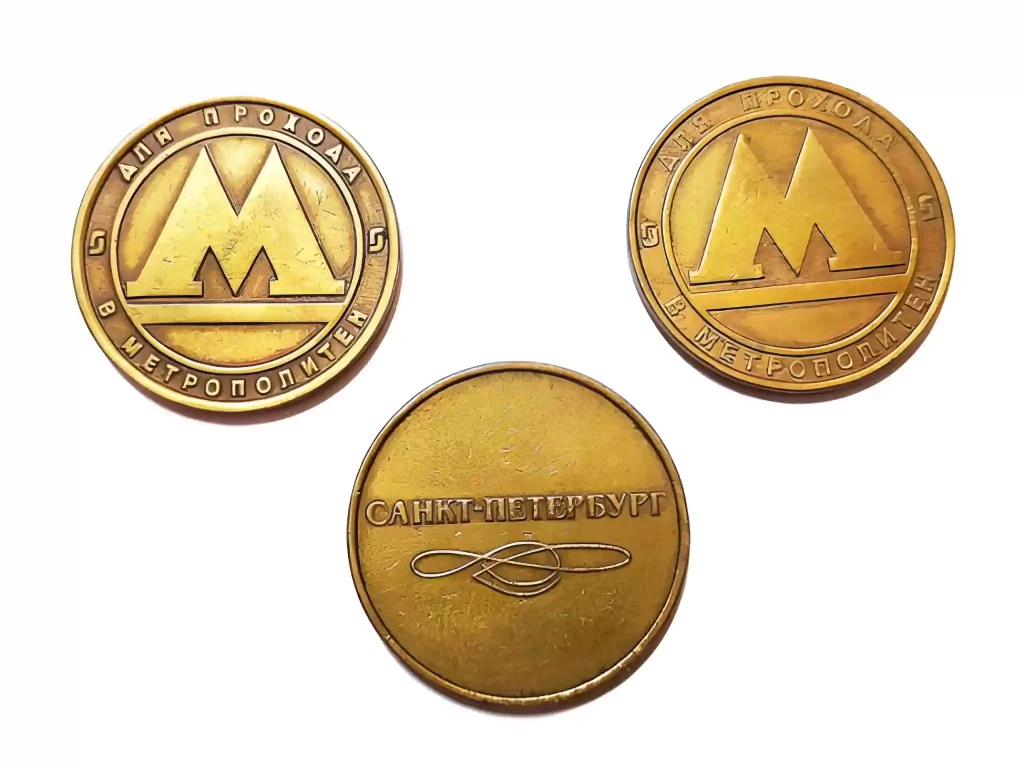 Close-up of laser-engraved brass coins showing fine text details.