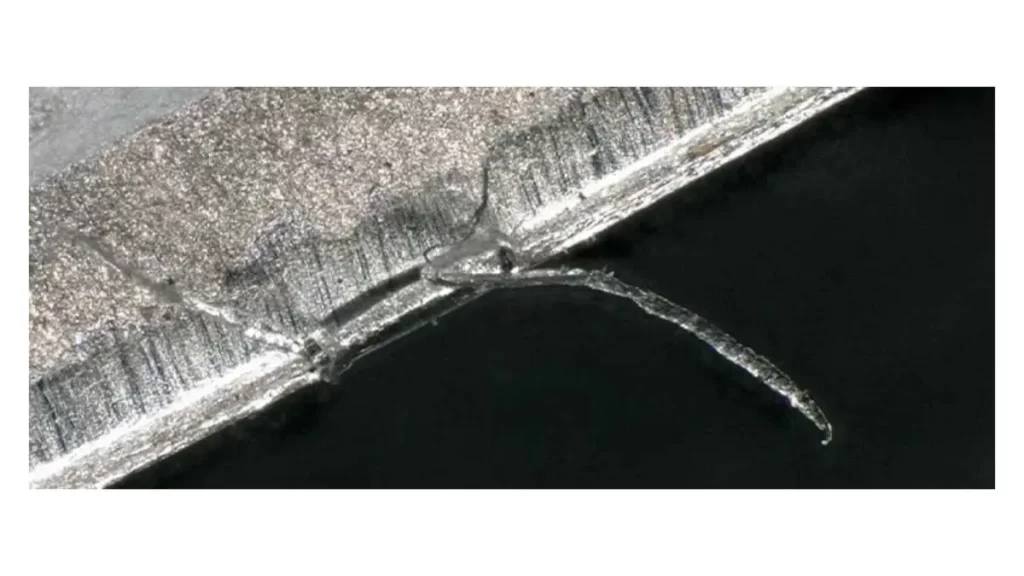 An image showing chipping on the surface of a metal workpiece. The defect is clearly visible as small pieces of material are broken off.