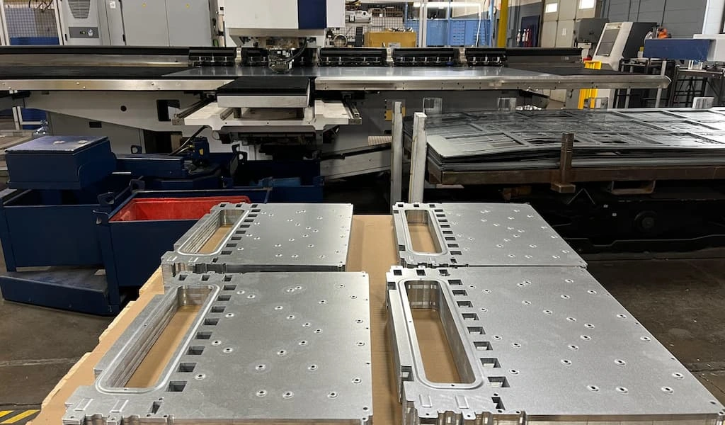 Punched metal parts with several holes, laying over a table