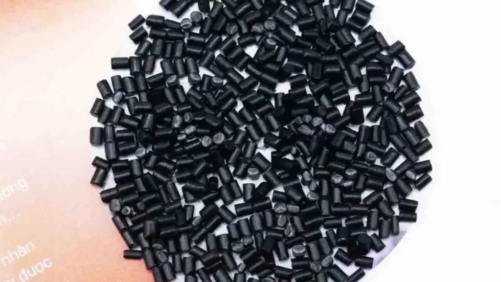 A close-up of a pile of small, black cylindrical plastic pellets.