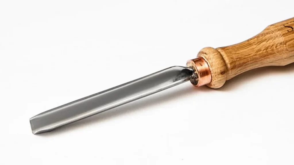 A close-up image of a parting tool used in machining. The tool has a narrow, flat cutting edge designed to cut off sections of a workpiece on a lathe.