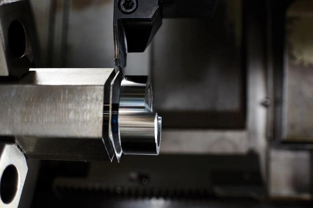 A close-up view of the parting operation, the finished section is about to be separated from long bar