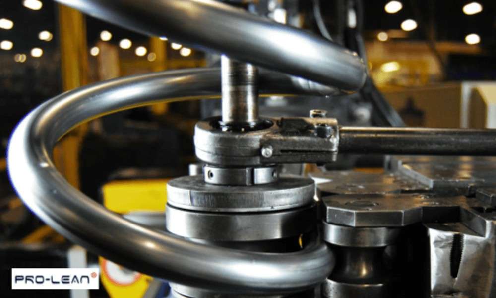 Close-up of metal tube bending machine with a curved tube being formed.