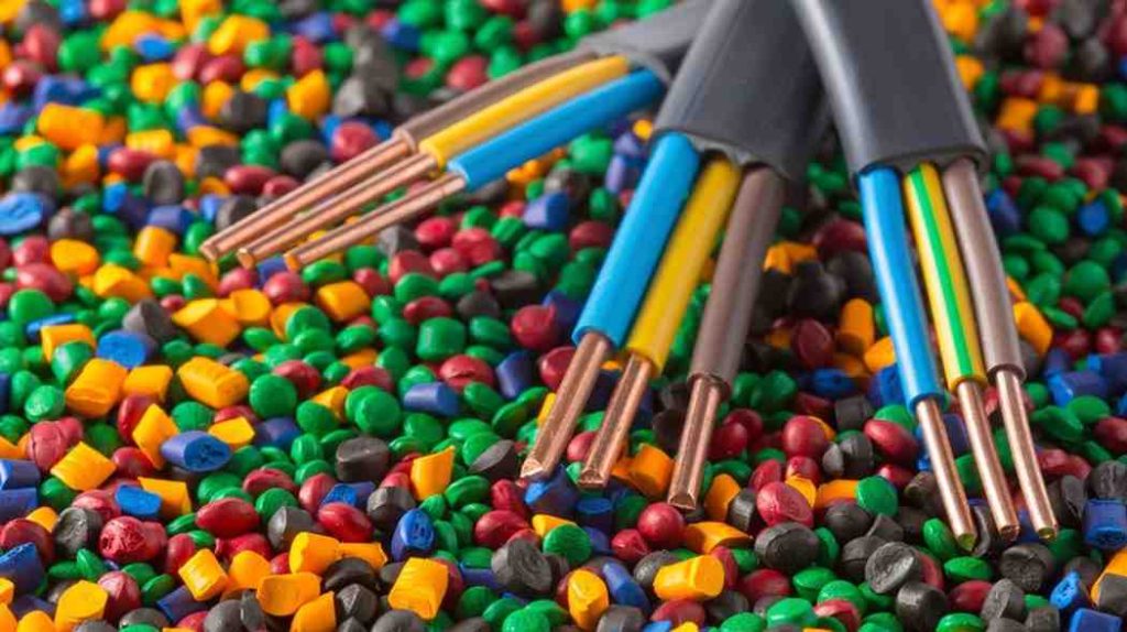 Colorful plastic pellets and stripped electrical wires on a surface.