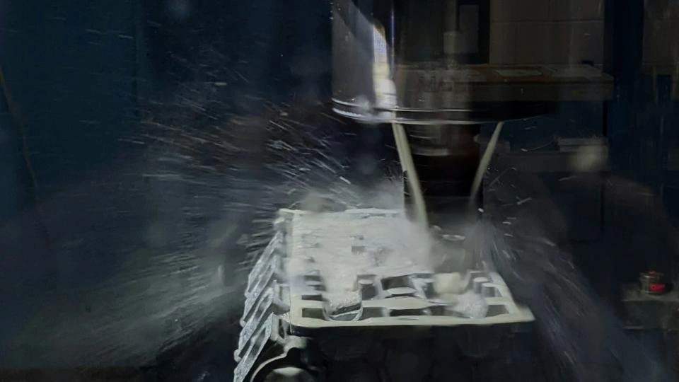 A close-up image of a CNC machine cutting a metal part, with coolants spraying over the tool and workpiece.