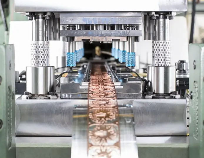 Progressive die stamping operation on a metal strip