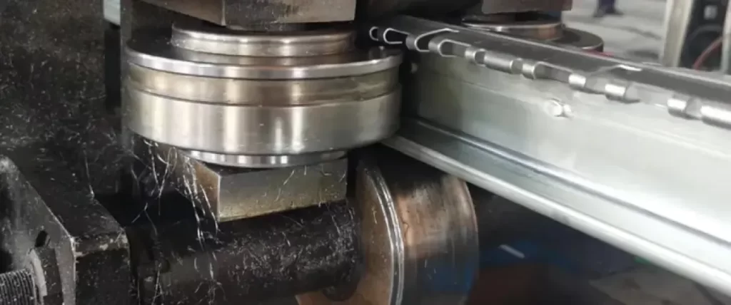 Warped metal in a roll forming machine showing deformation during processing
