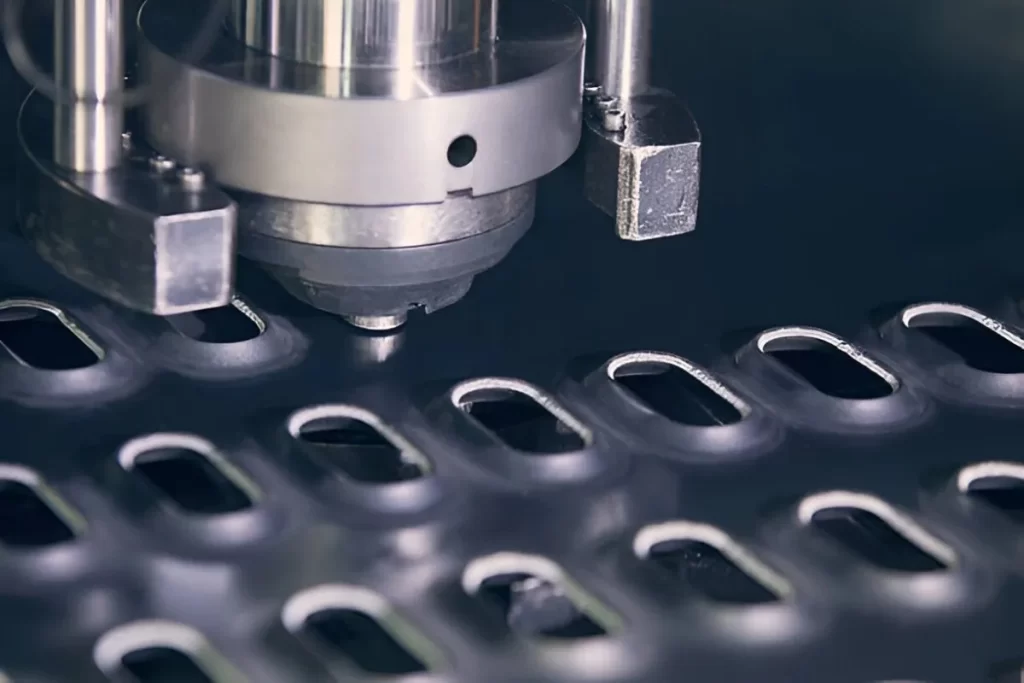 A close-up view of an industrial sheet metal punching machine in operation. The machine is actively punching holes into a metal sheet with high precision and force.