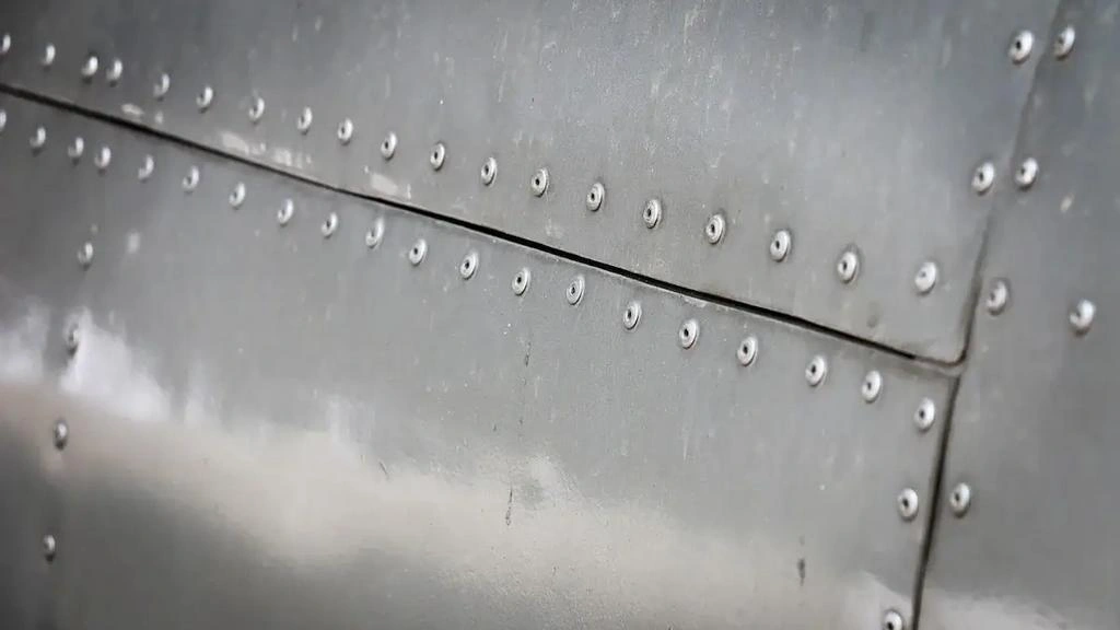 A close-up view of sheet metal panels joined with multiple rivets