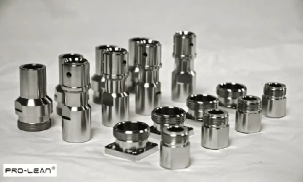 Assortment of shiny, machined metal parts on a light surface, showcasing precision engineering.