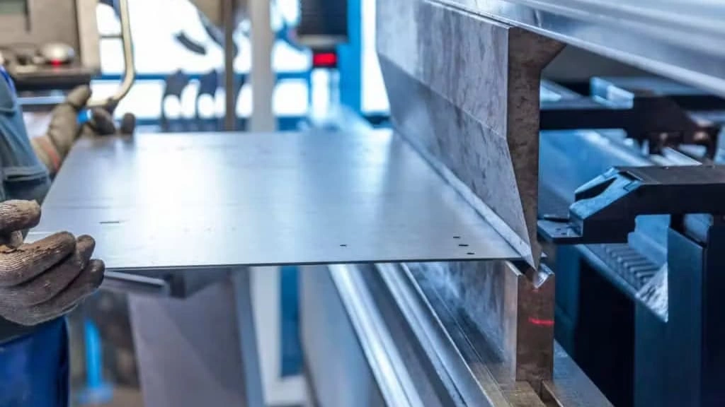 An image showing the steel sheet bending in a V-die to fabricate a custom part.  