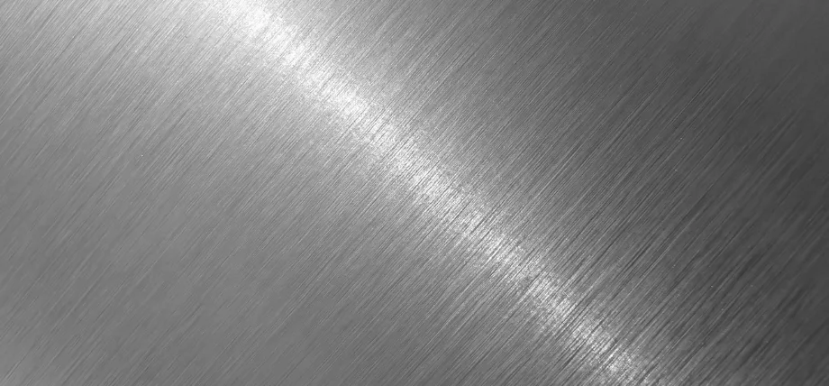 brushed lines on a gray steel surface with white flare
