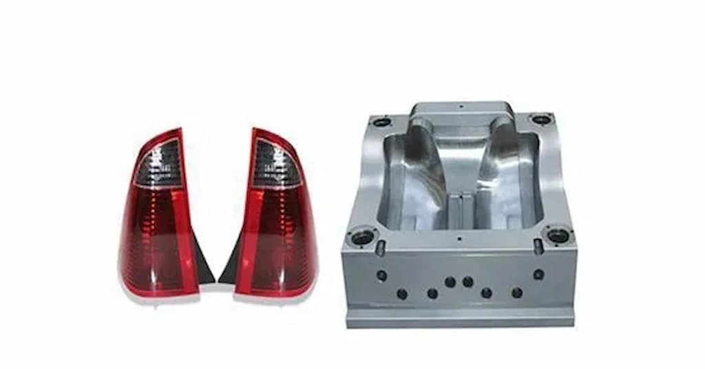 Injection molded car tail lights in red color at left and mold halve on the right.