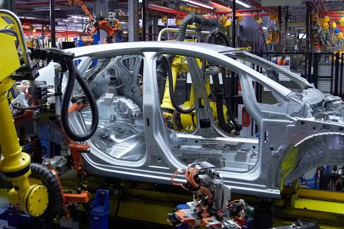 A close up view of an automotive body in assembly with white teflon coating