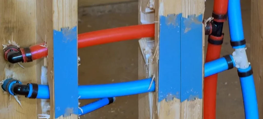 A set of blue and red joined plastic pipes curved due to thermal expansion