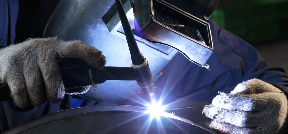 Person holding a welding torch and electrode for tig welding with a spark