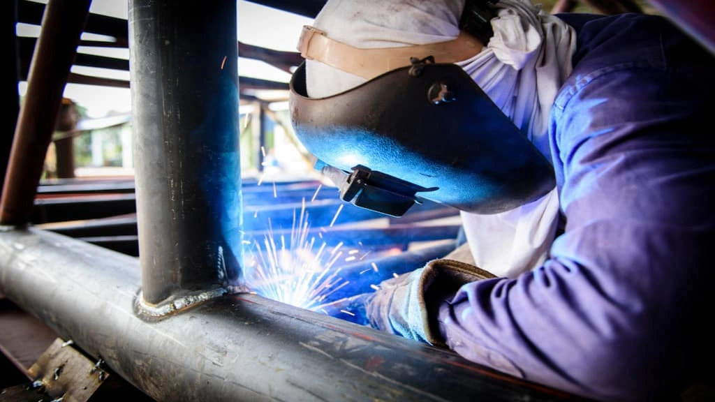 A mechanic performing a welding operation for the tubular truss structure
