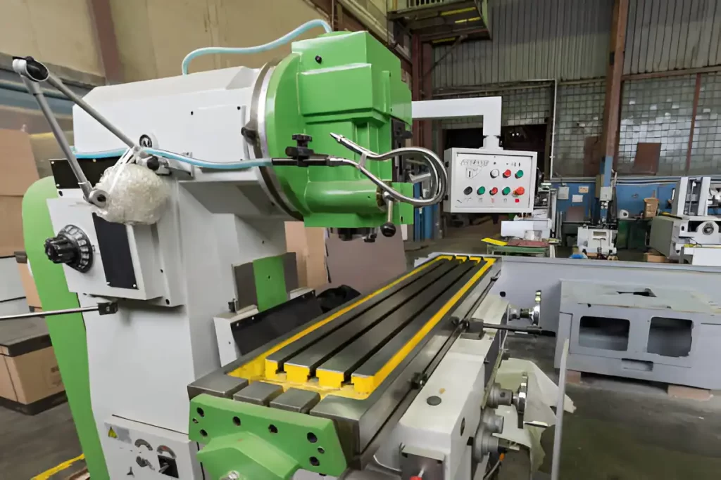 A large vertical milling machine with a work table.